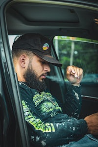 a man smoking a cigarette in the back seat of a car
